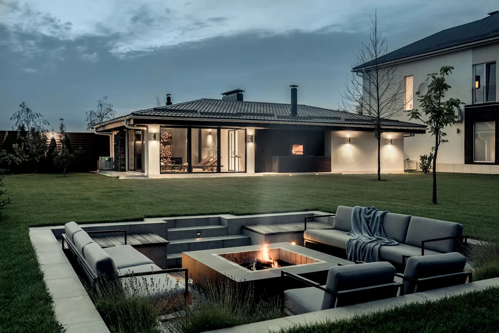 Sunken fire pit lounge area with built-in seating at dusk