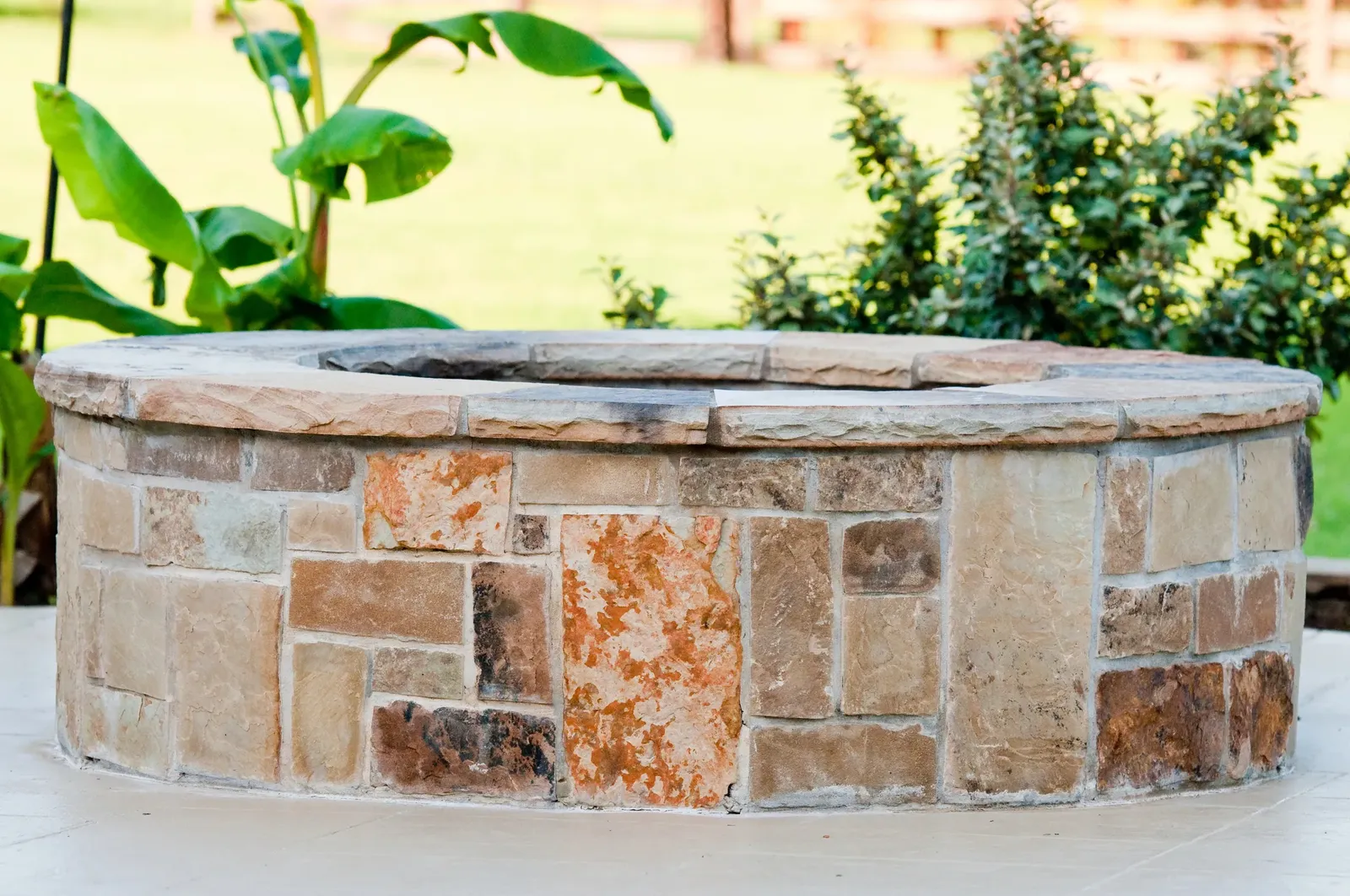 Stone-surround fire pit set into a paved patio