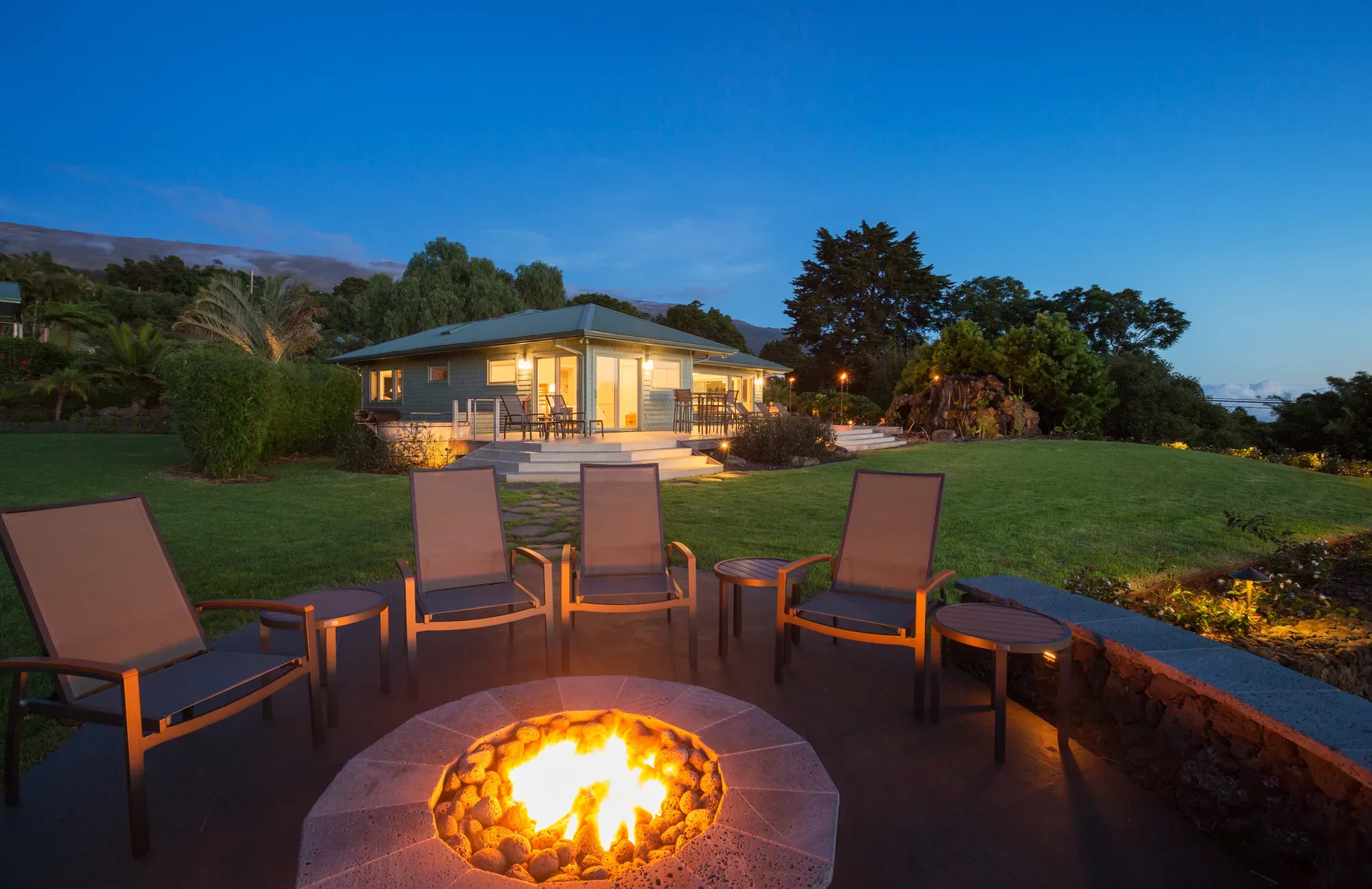 Built-in fire pit with lava rock surround and lounge chairs