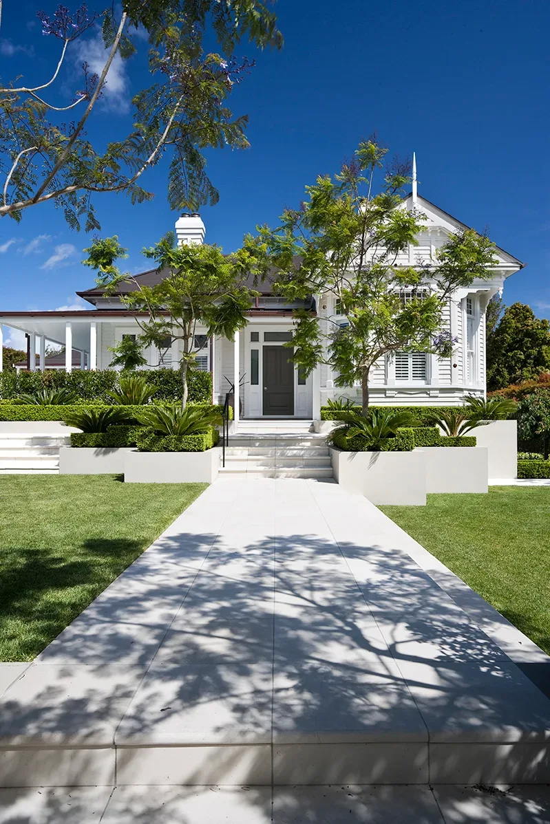 Manicured front garden with clipped hedges leading to a home entrance