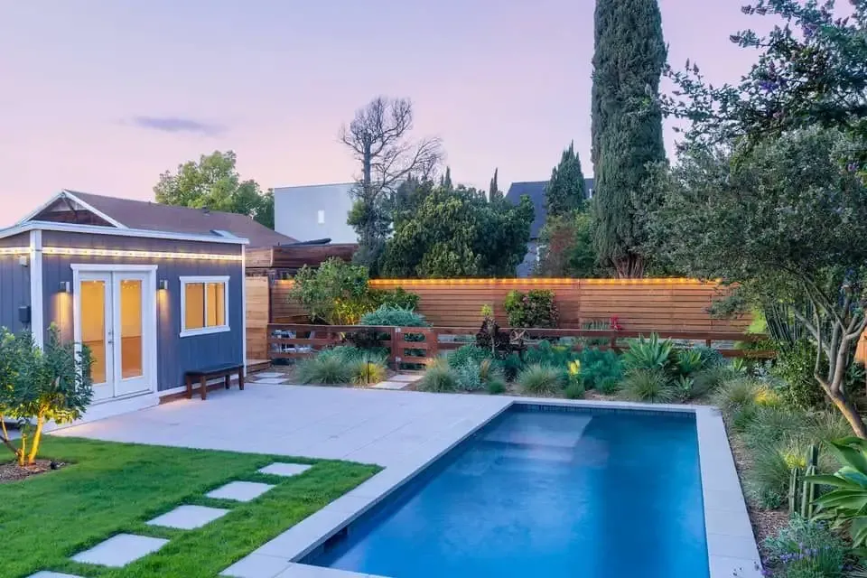 Poolside timber deck and paving lit at dusk