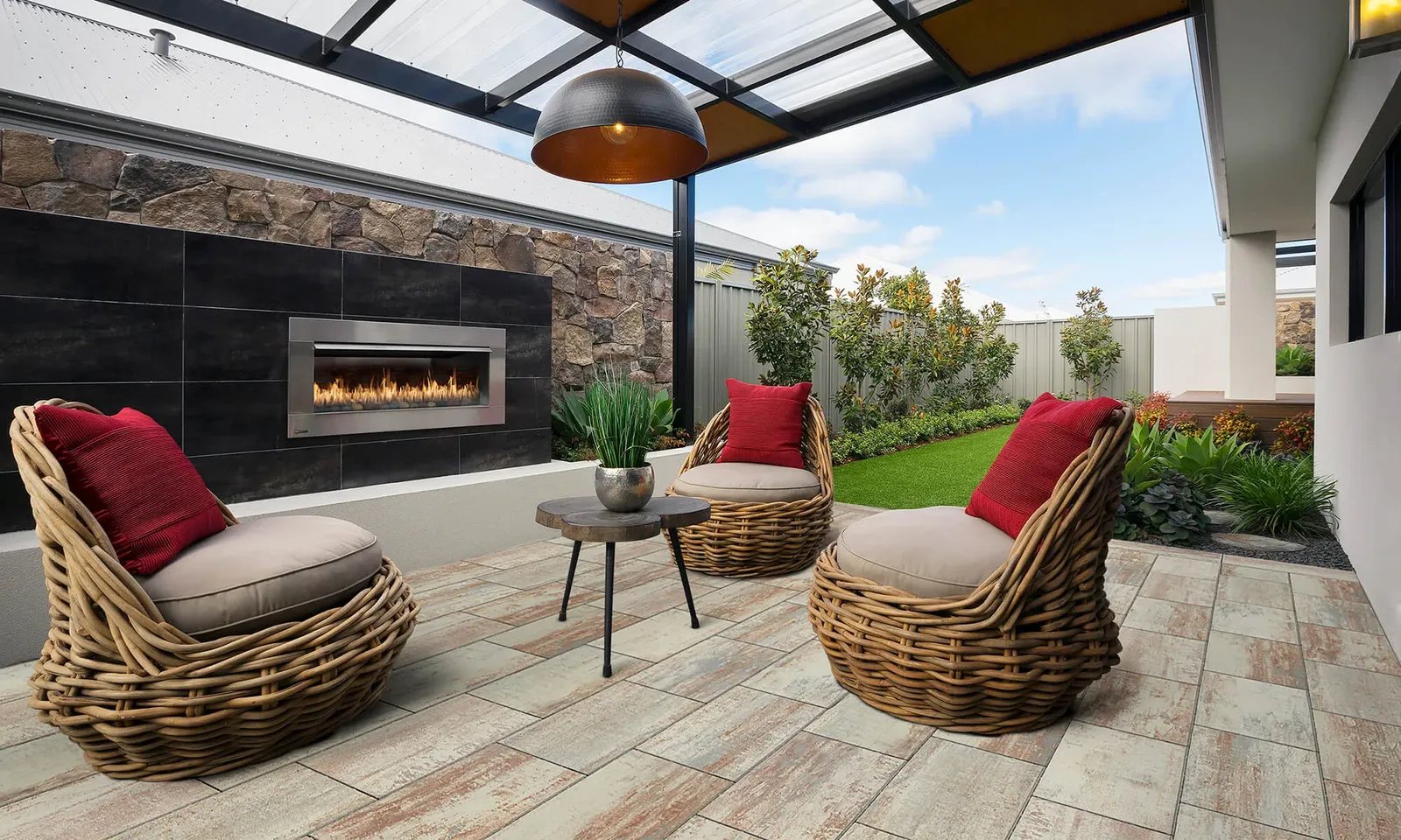 Stone-clad retaining wall with a built-in outdoor fireplace and patio seating